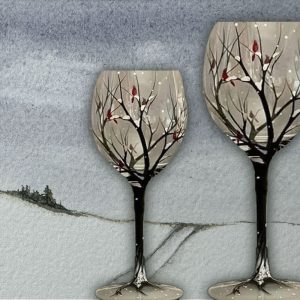 Two handprinted wine glasses showing a winter scene.