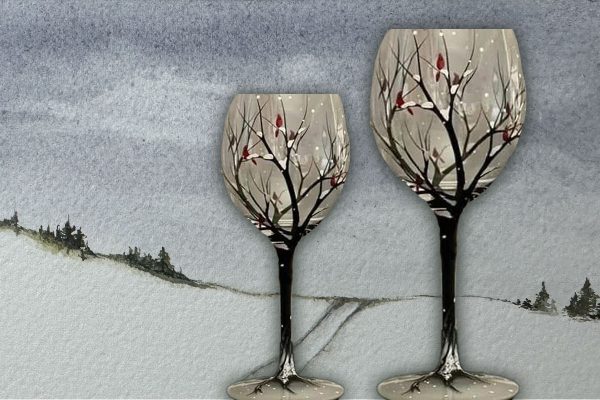 Two handprinted wine glasses showing a winter scene.